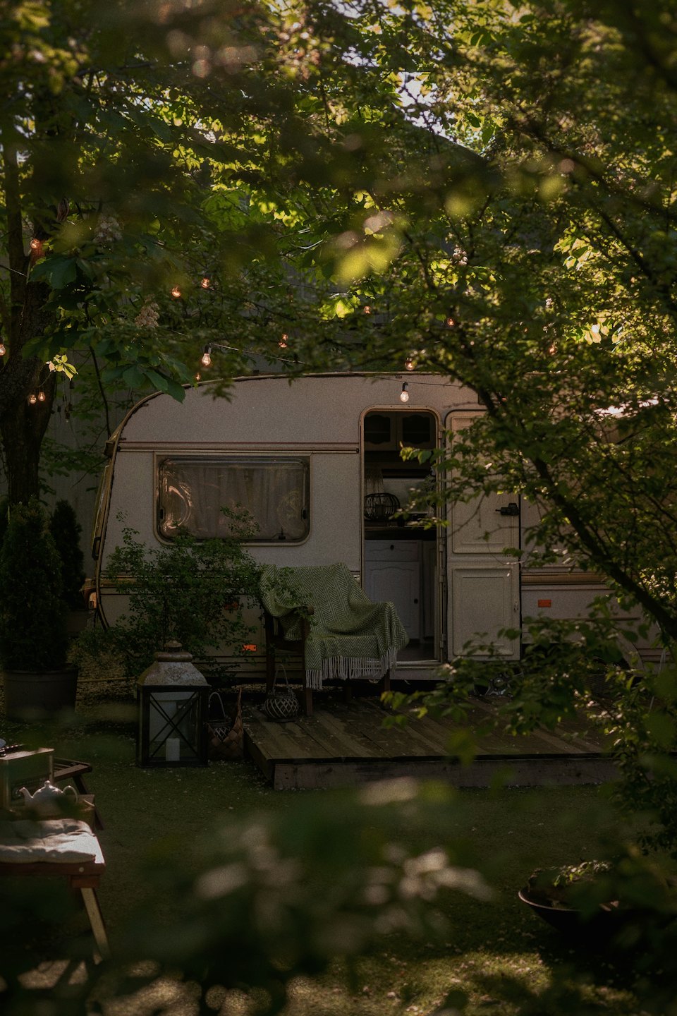 Záhradná retro karavan s otvorenými dverami a terasou.